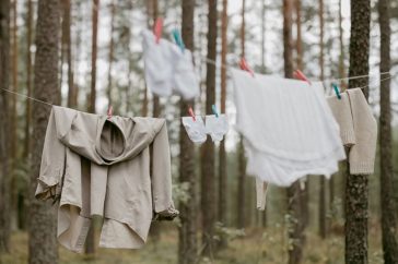 Clothes hanging on a line in a serene forest, creating a rustic outdoor laundry scene.