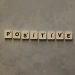 Scrabble tiles spelling 'Positive' on a textured surface, conveying optimism.